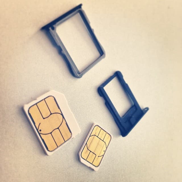 Illustrative: SIM cards and trays for consumer smartphones. South Africa's reform targets how such SIMs are registered and verified, not the hardware itself.