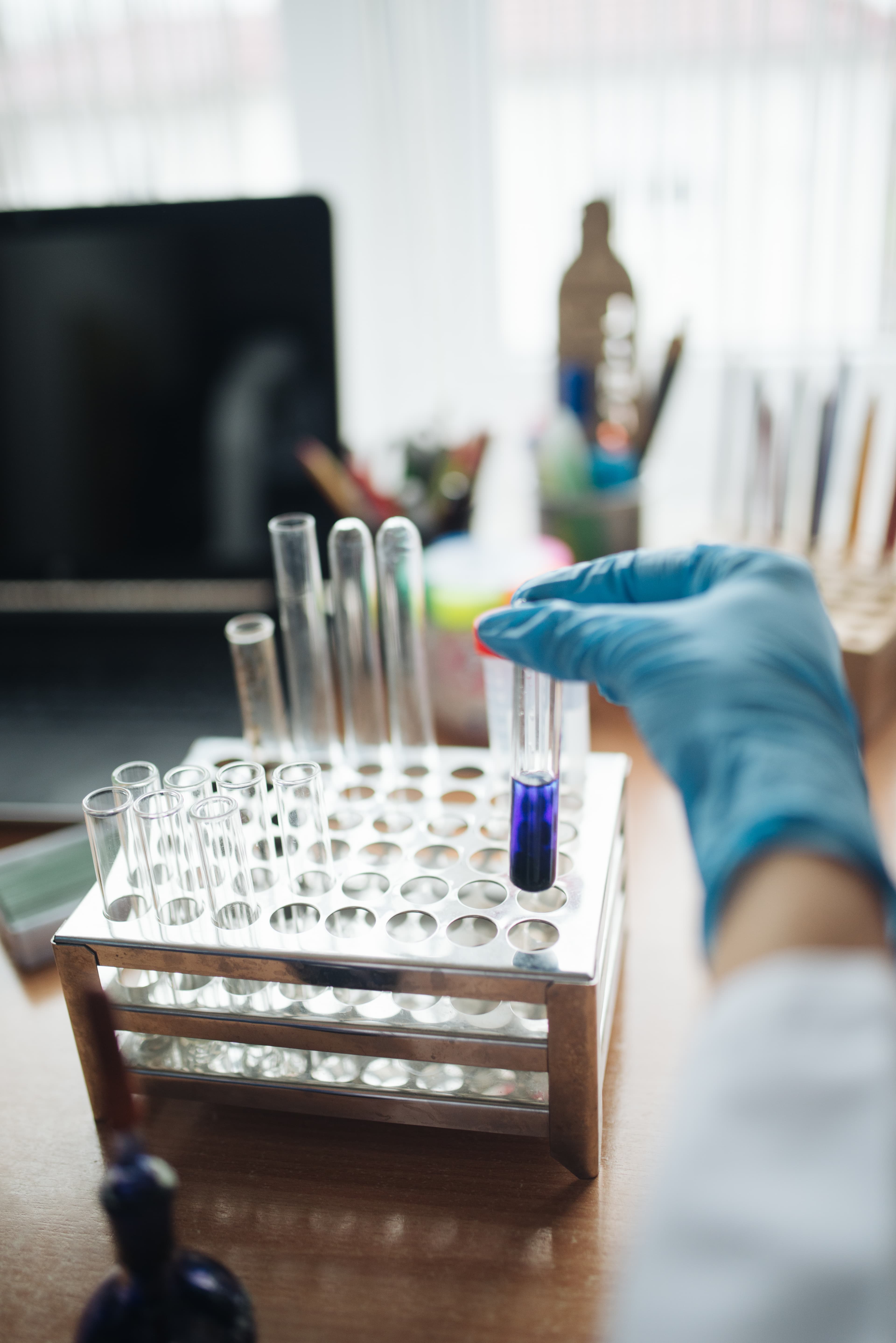 Illustrative: a lab technician handles a test tube. Reme-D's molecular diagnostic kits are designed to be read on standard PCR equipment already installed in regional labs.