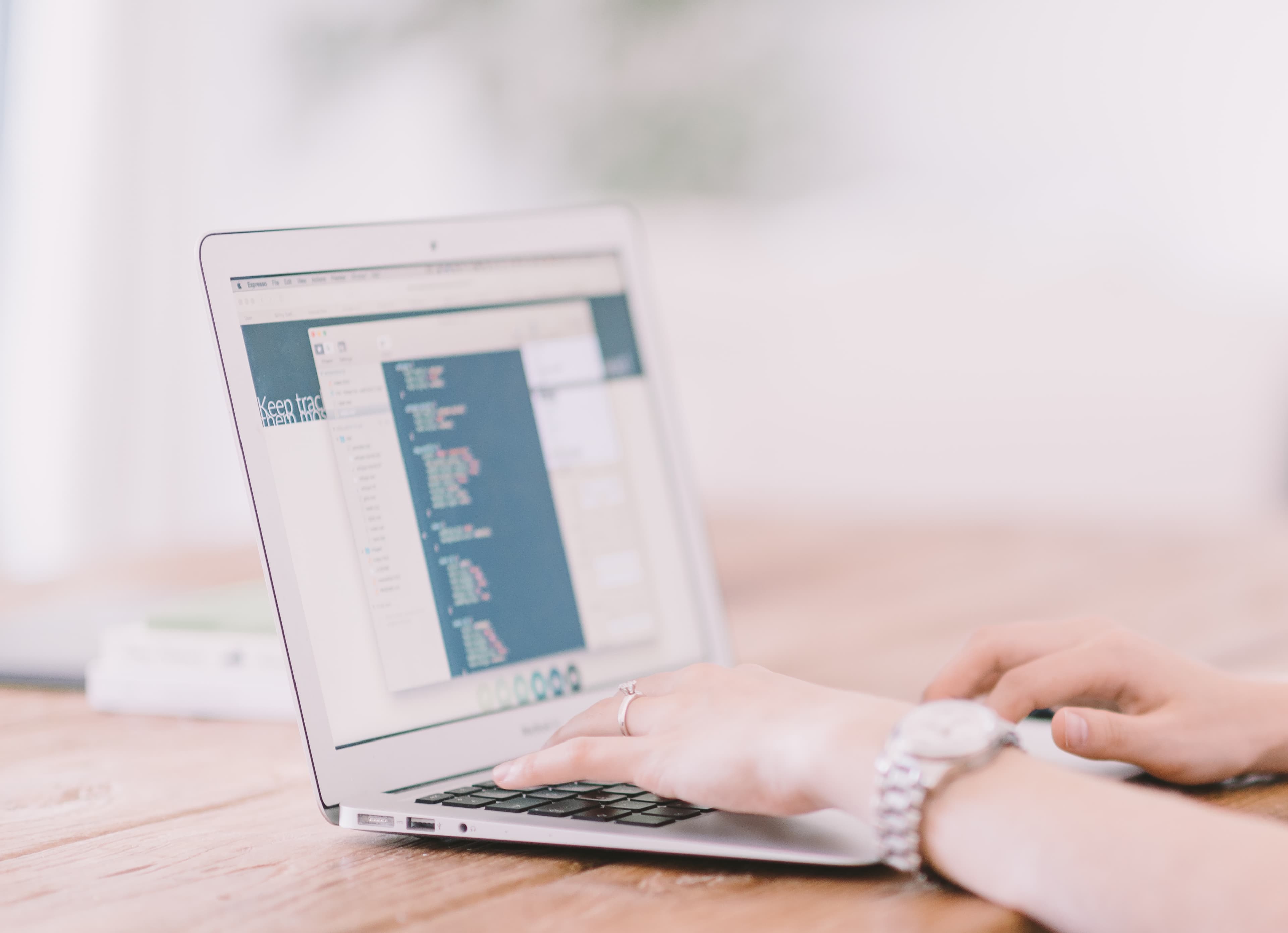 Illustrative: a developer at a laptop. Anthropic's Claude Fable 5 is billed at $10 per million input tokens and $50 per million output tokens once promotional access lapses.