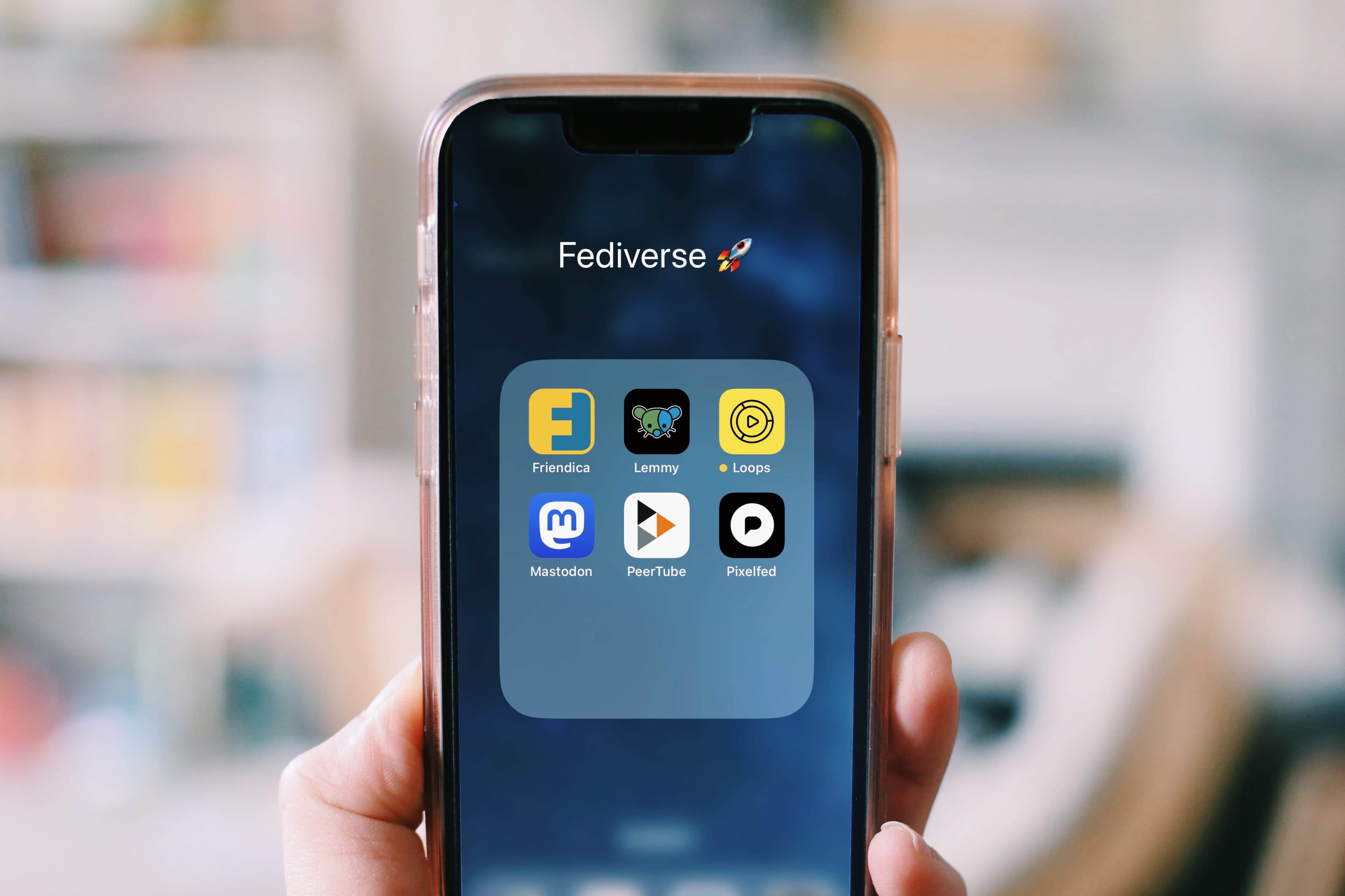 Illustrative: a hand holding a smartphone with app icons on screen. Not a photo of Siri AI, which is not yet available to test in most African markets.