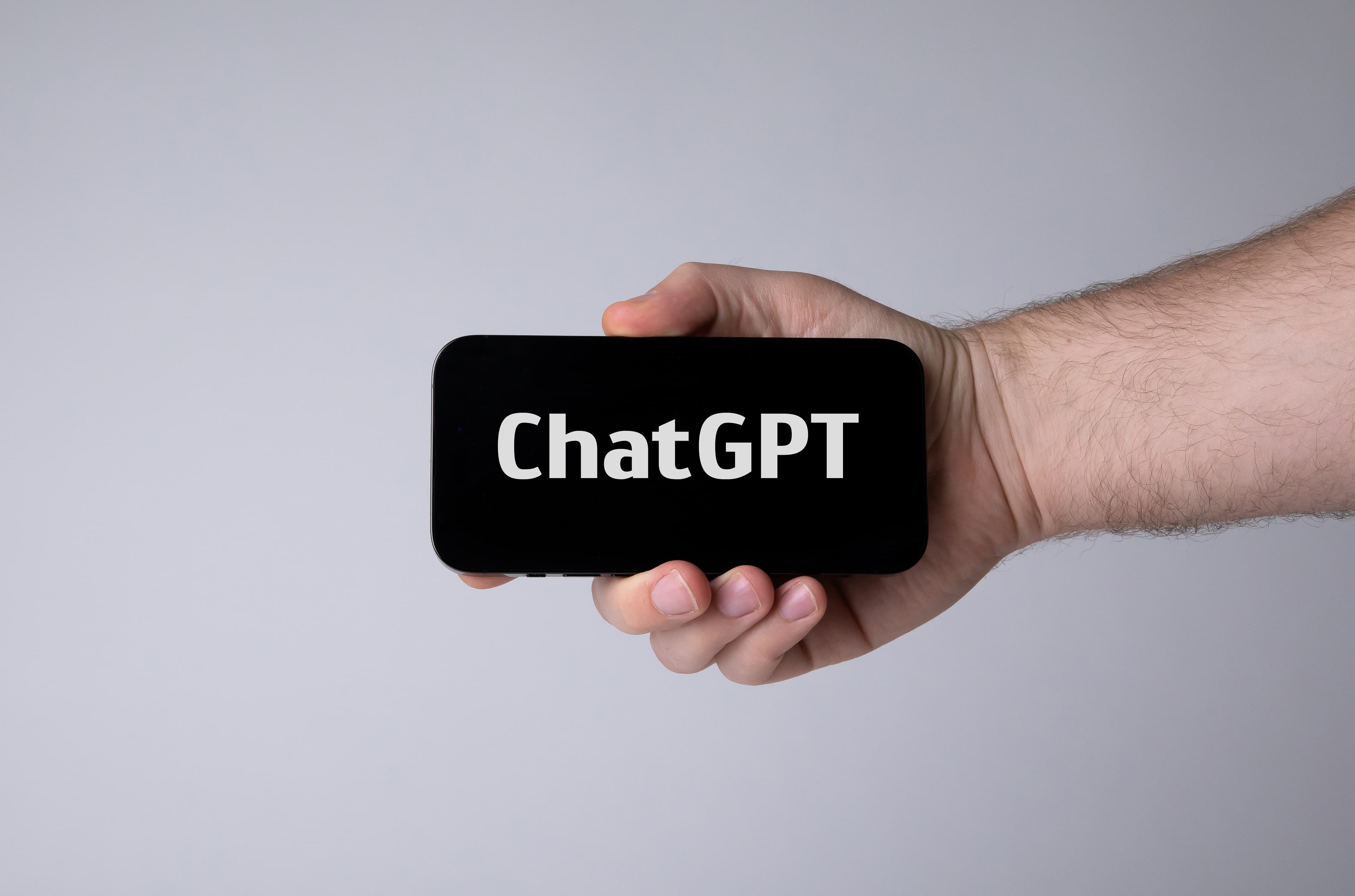 Illustrative: a hand holding a smartphone running ChatGPT. Paystack's Index lets users in Nigeria complete payments by instructing AI assistants such as ChatGPT, Claude and OpenClaw.